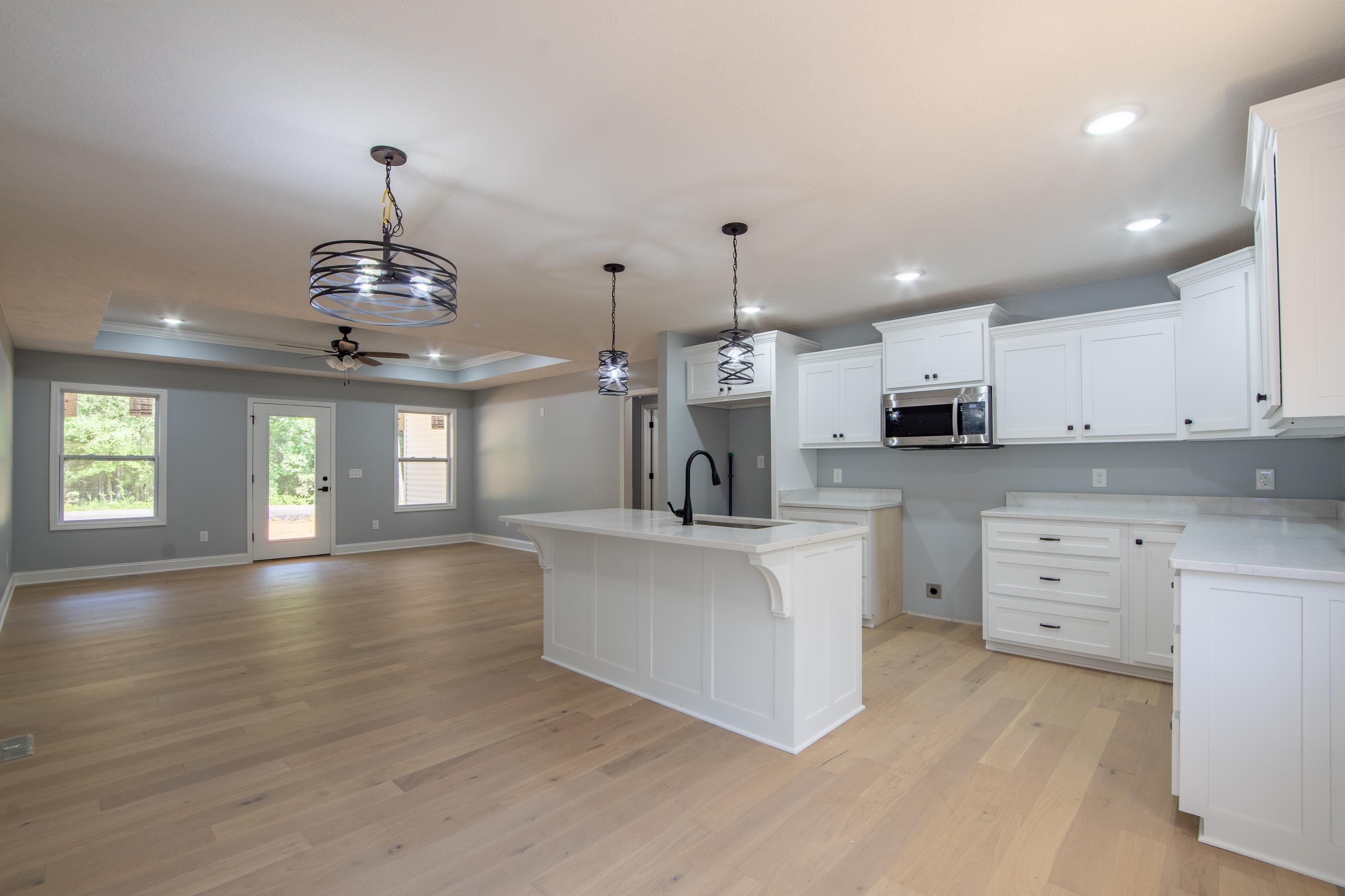 260 Range Road Savannah, TN 38372 - Photo 4 of 40 a large white kitchen with lots of counter space wooden floor and ceiling cabinets