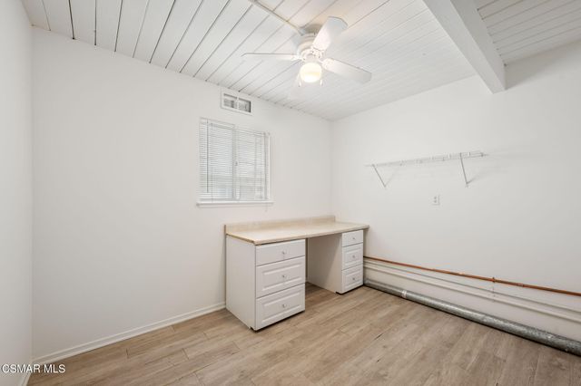 an empty room with wooden floor and ceiling fan