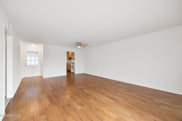 a view of empty room with wooden floor