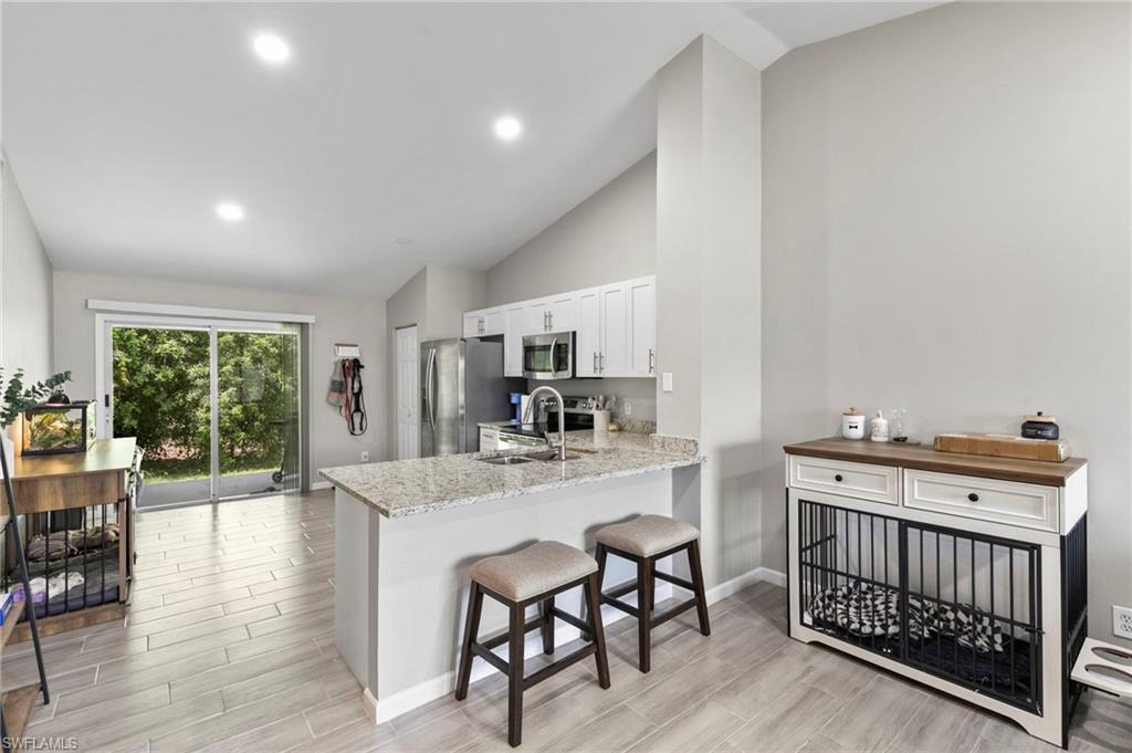 8264-8268 Matanzas Road Fort Myers, FL 33967 - Photo 5 of 33 a kitchen with stainless steel appliances a dining table chairs and wooden floor