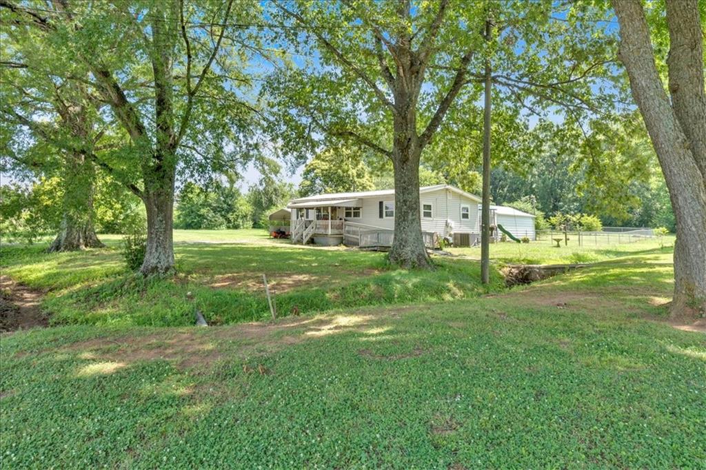 2454 Hall Station Road Northwest Adairsville, GA 30103 - Photo 21 of 35 a view of a house with a big yard and sitting area