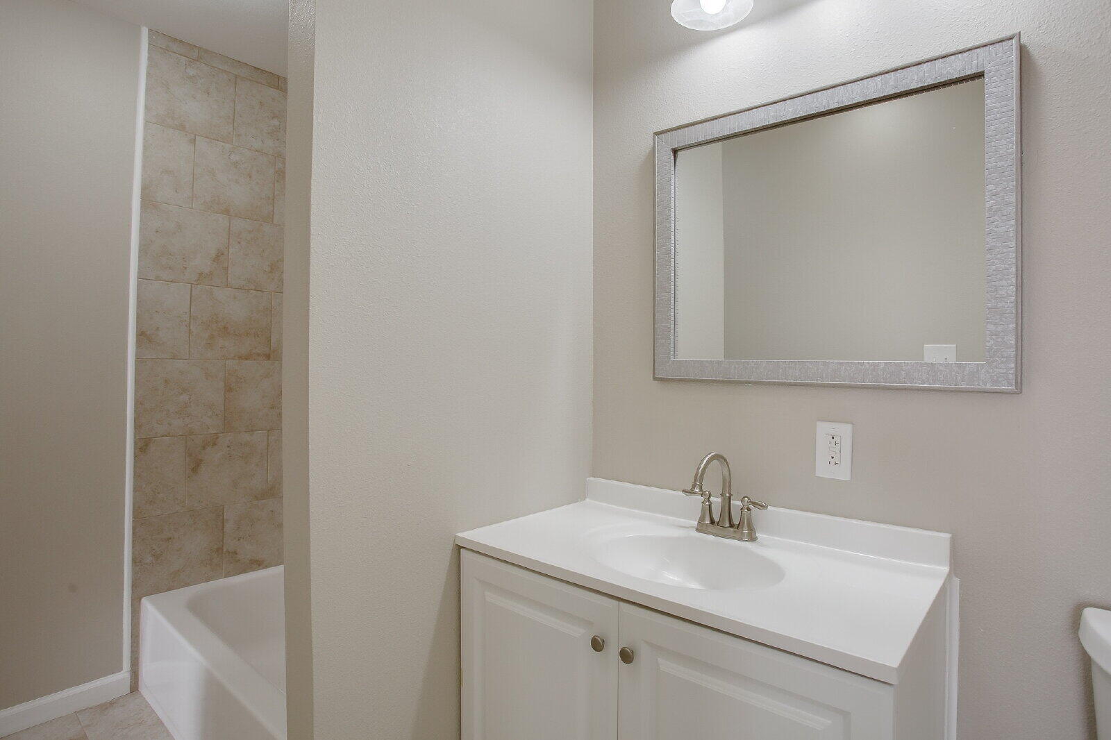 1909 16th Street, Unit FRONT Lubbock, TX 79401 - Photo 12 of 13 a bathroom with a sink a vanity and a mirror