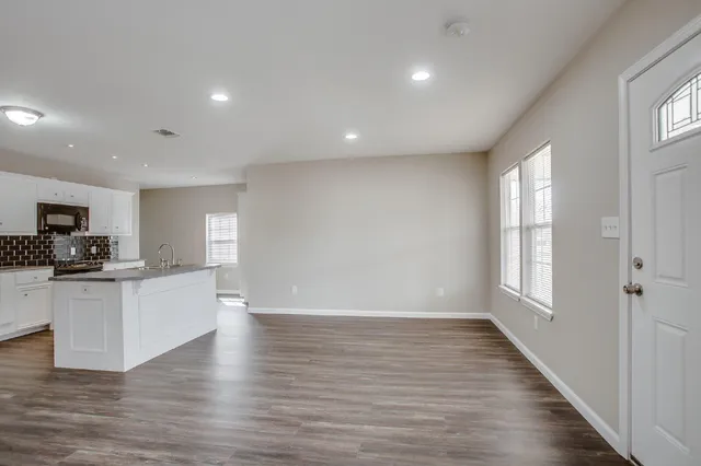 a view of a kitchen with sink microwave and cabinets