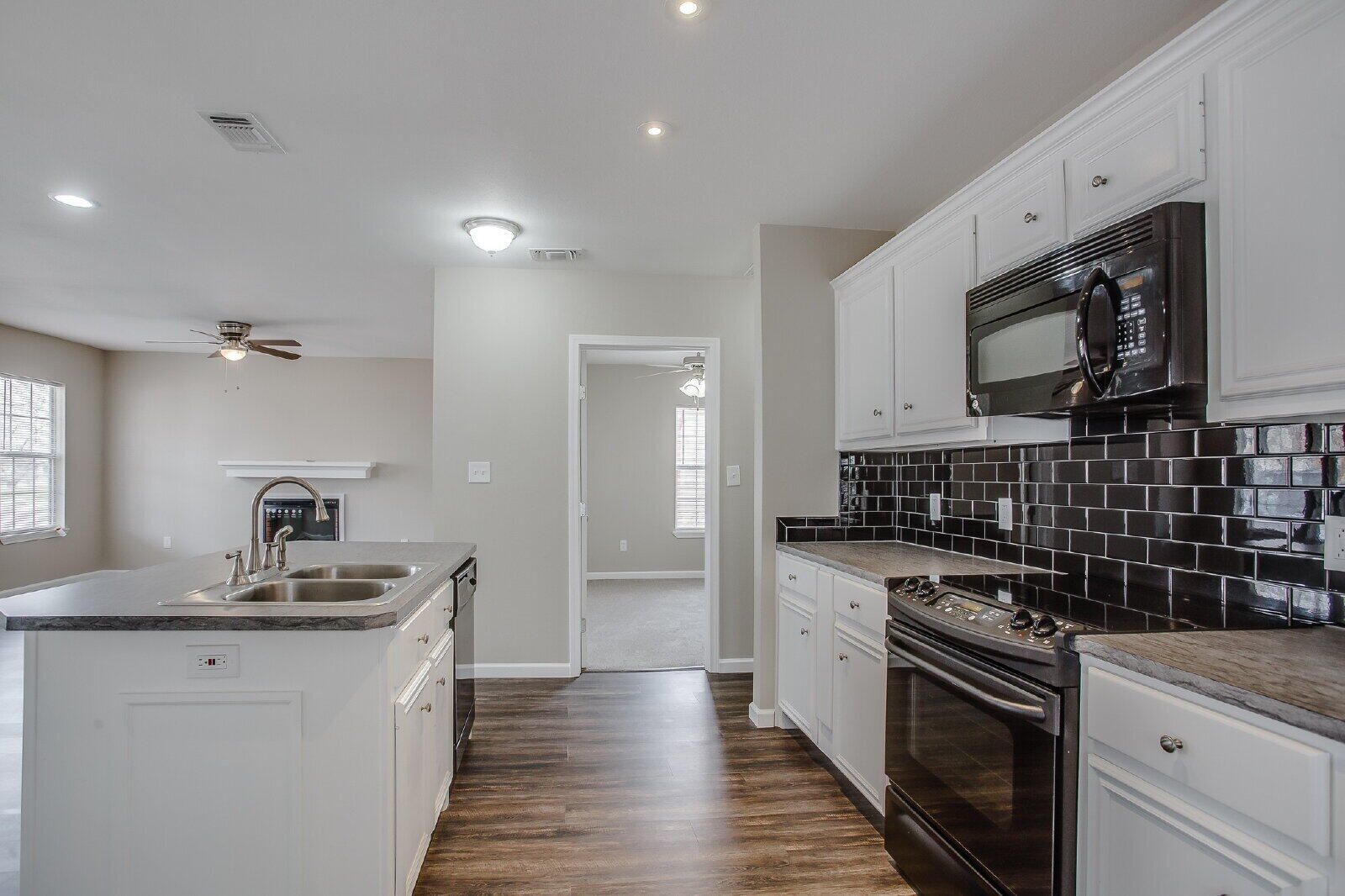 1909 16th Street, Unit FRONT Lubbock, TX 79401 - Photo 6 of 13 a kitchen with granite countertop a sink a stove and cabinets