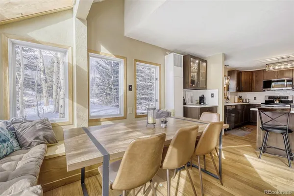 a dining room with furniture and large windows