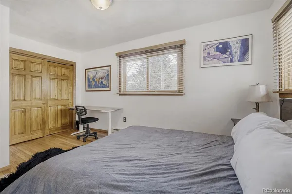 a bedroom with a bed and a table in it with window