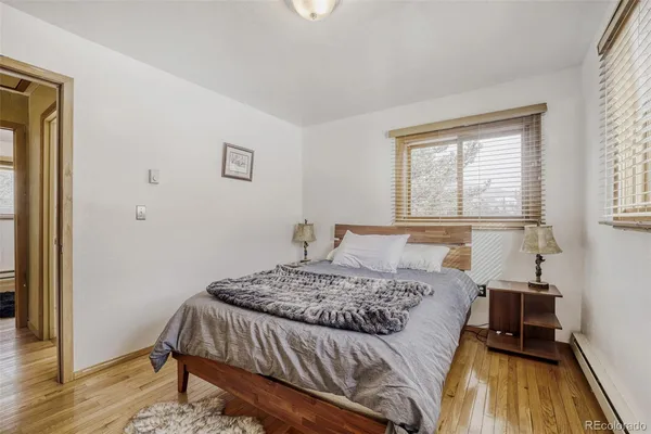 a bedroom with a bed and wooden floor