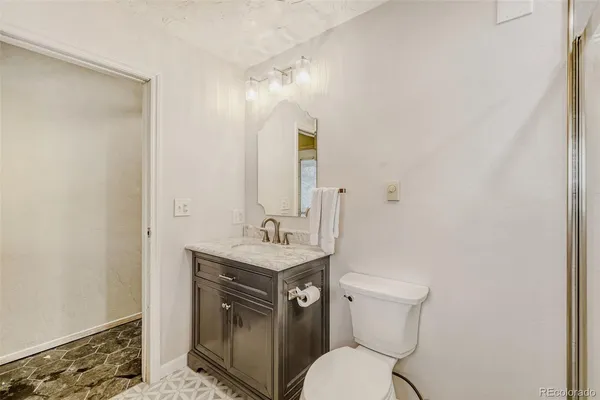 a bathroom with a toilet a sink and mirror