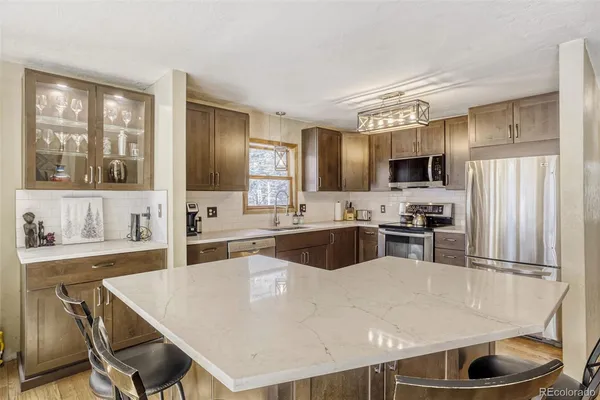a large kitchen with kitchen island a large counter top space appliances and cabinets