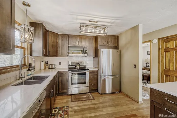 a kitchen with stainless steel appliances granite countertop a refrigerator stove and sink