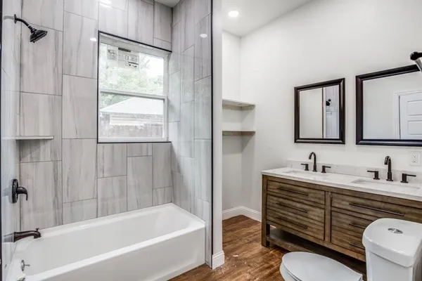 a bathroom with a tub sink toilet and mirror