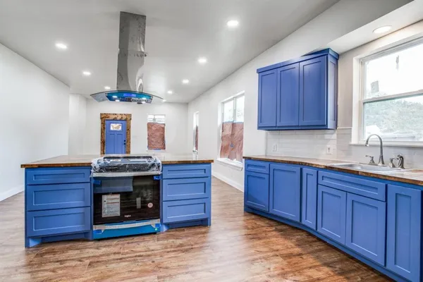 a kitchen with stainless steel appliances granite countertop wooden cabinets a window and a sink