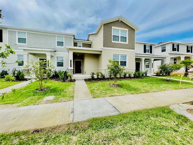 a front view of a house with a yard and potted plants