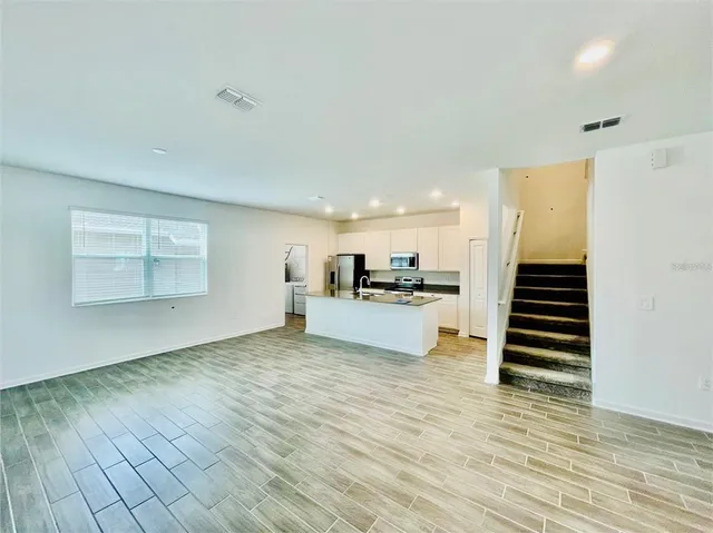 a view of kitchen with wooden floor and electronic appliances