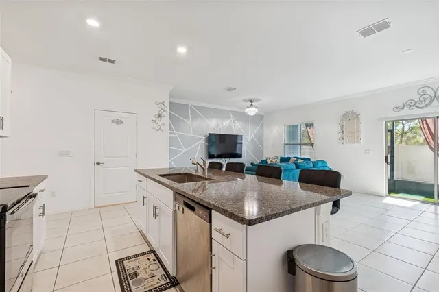 a kitchen with granite countertop stainless steel appliances a sink a stove and cabinets