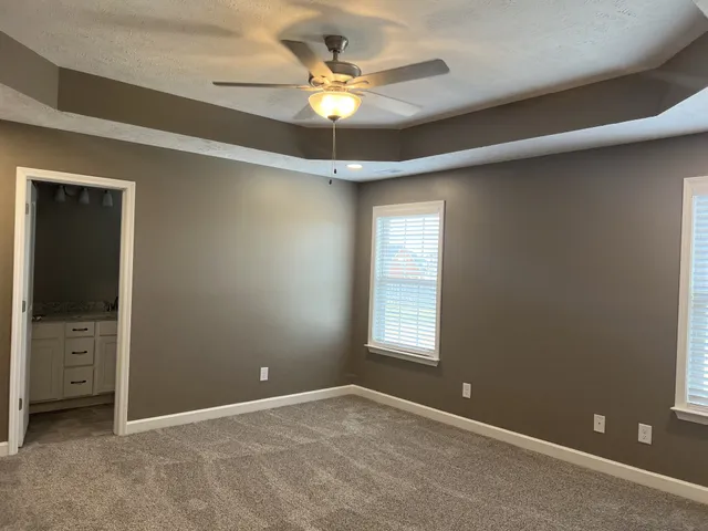 an empty room that has a window and a ceiling fan
