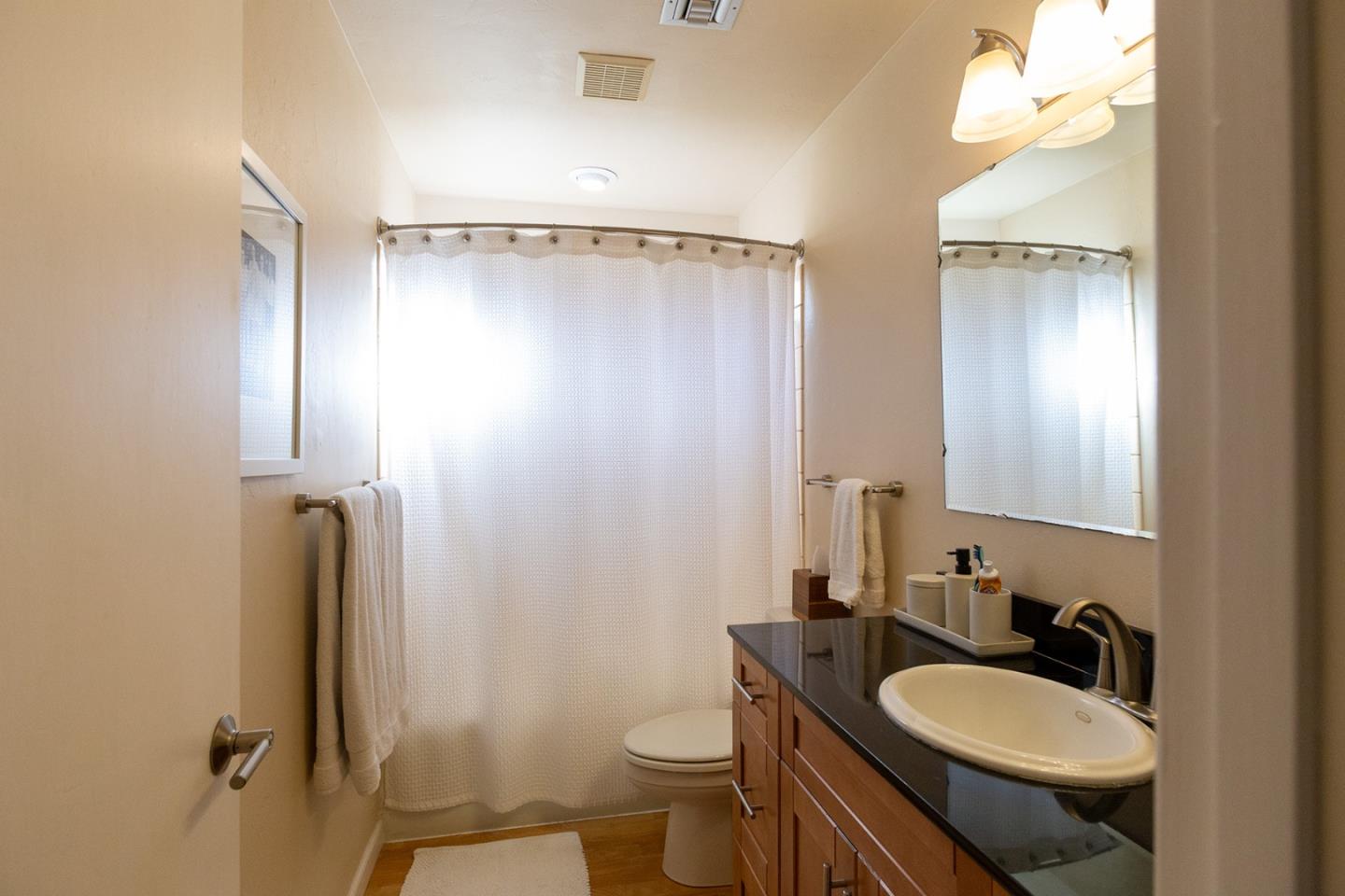 779 Alice Street Monterey, CA 93940 - Photo 18 of 27 a bathroom with a granite countertop sink toilet and shower