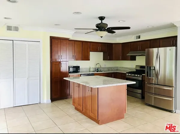 a kitchen with stainless steel appliances granite countertop a stove a refrigerator and a sink