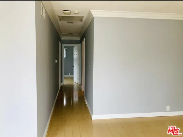 a view of a hallway with wooden floor