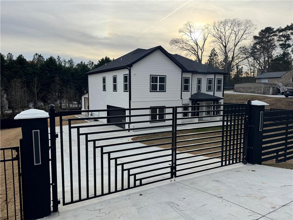 a view of a house with wooden fence next to a road