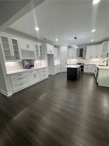 a kitchen with a white cabinets and wooden floor