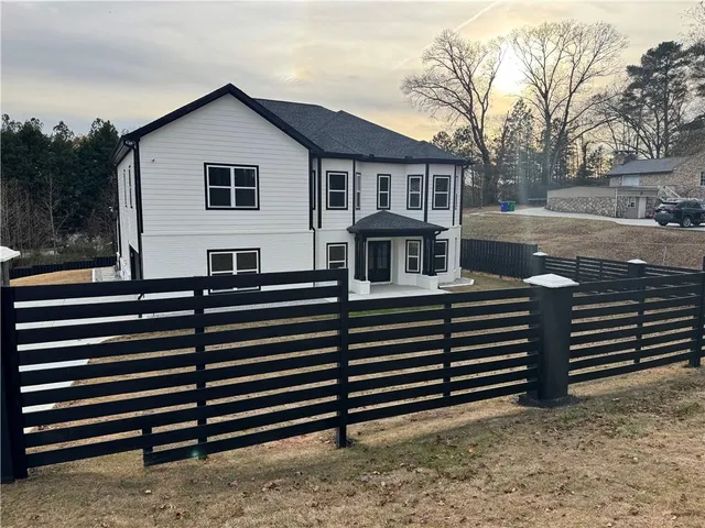 a view of a house with wooden fence