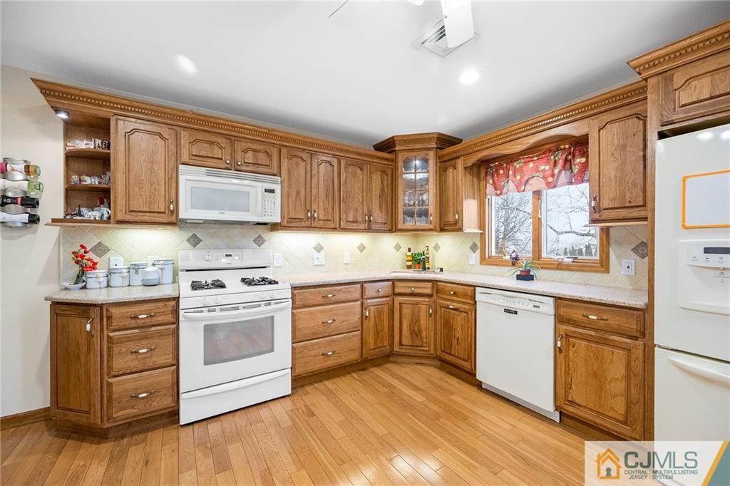 41 Ferris Road Edison, NJ 08817 - Photo 25 of 33 a kitchen with stainless steel appliances granite countertop a stove top oven a sink dishwasher and white cabinets with wooden floor
