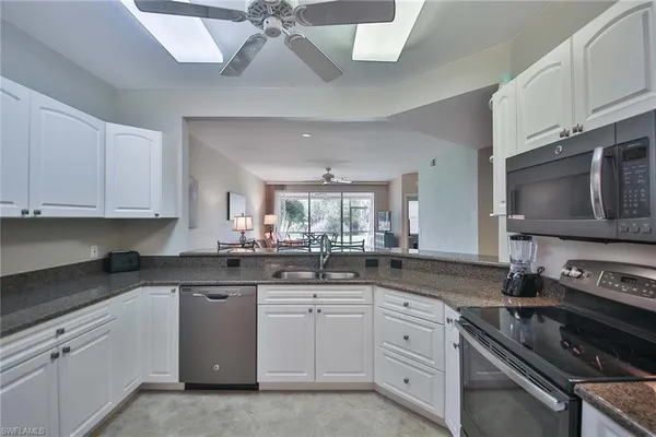 a kitchen with white cabinets and appliances