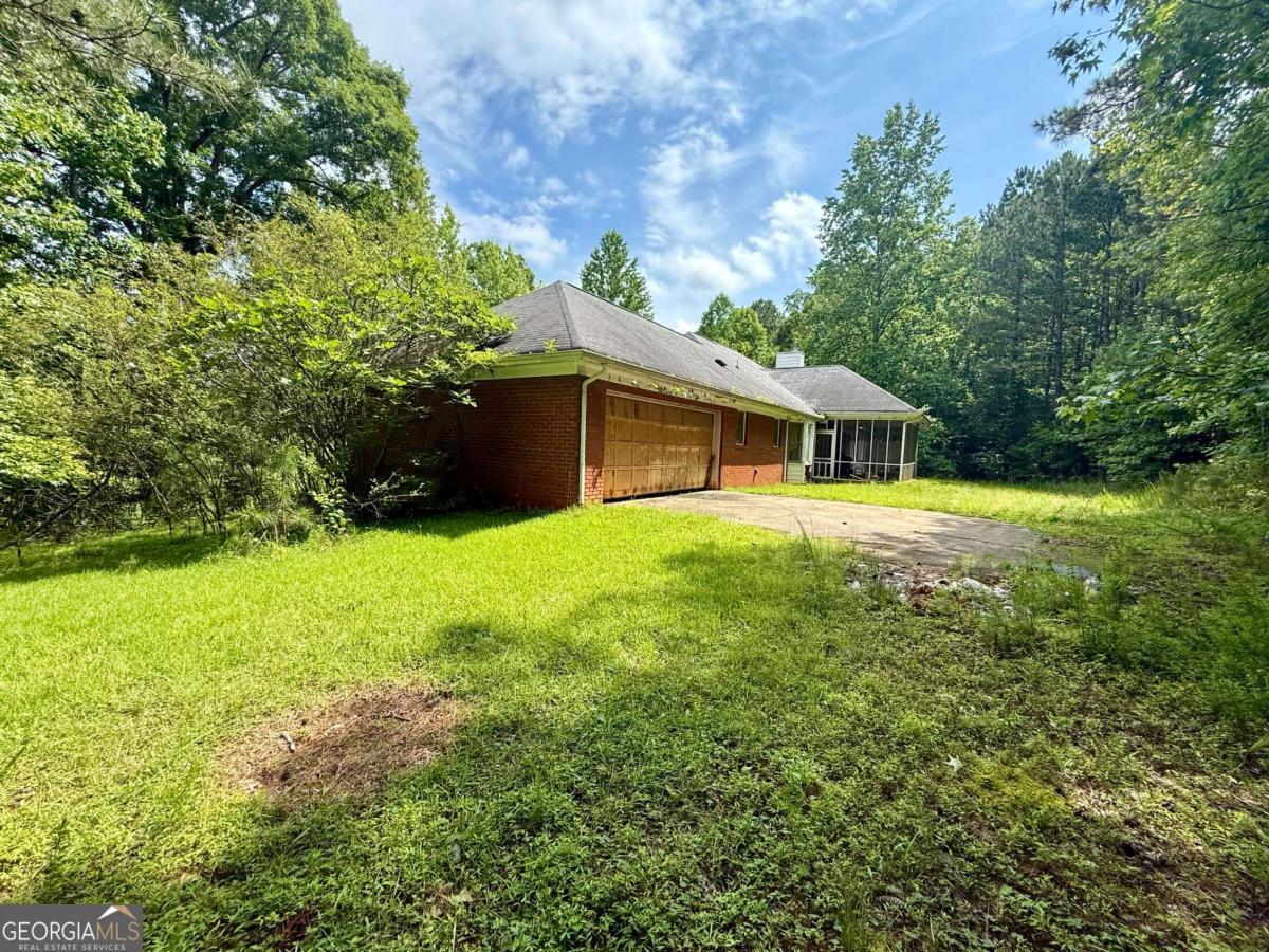 8872 Conners Road Villa Rica, GA 30180 - Photo 6 of 20 a white house with a big yard and large trees