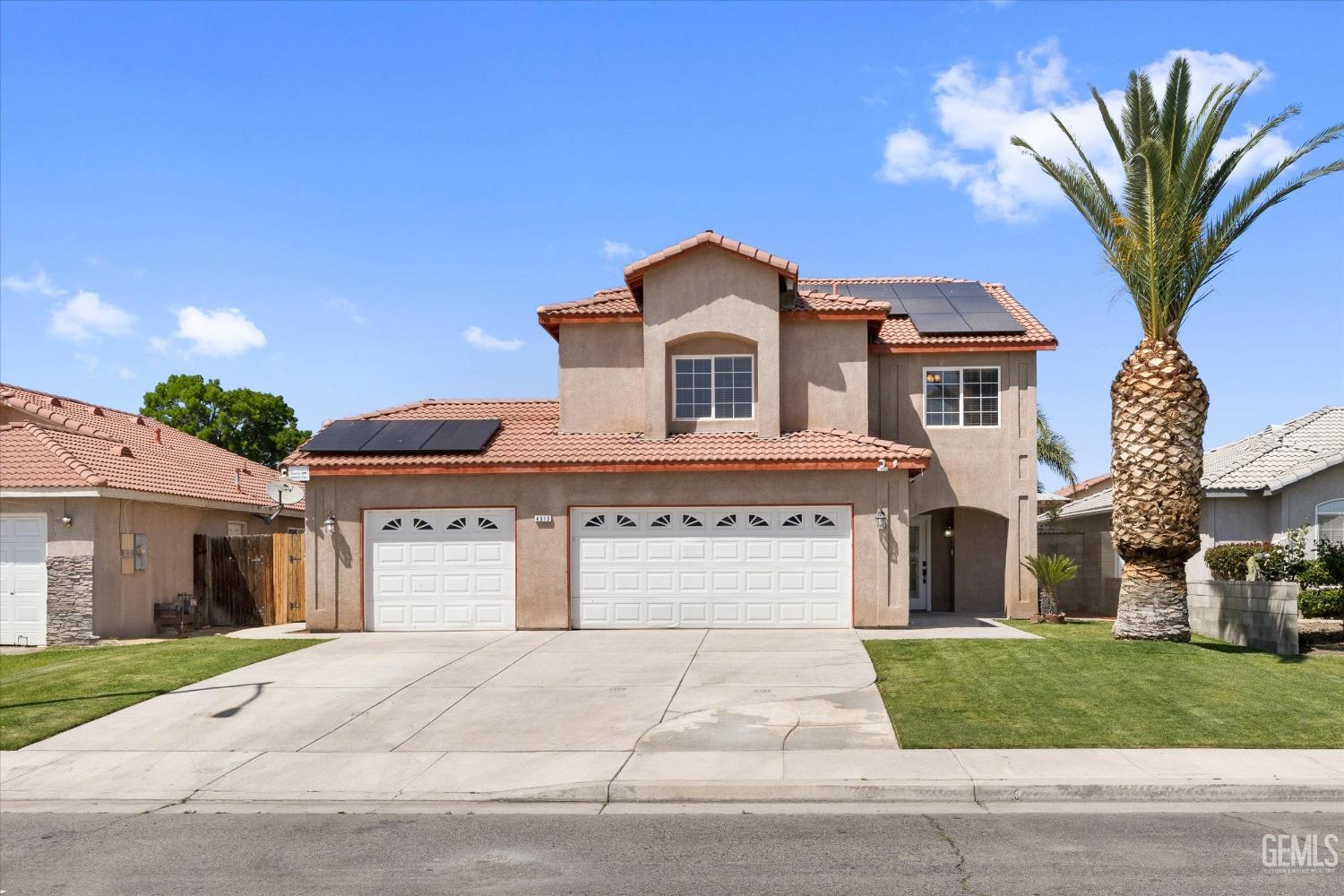 Undisclosed Address Bakersfield, CA 93313 - Photo 11 of 48 a front view of a house with a garden and garage