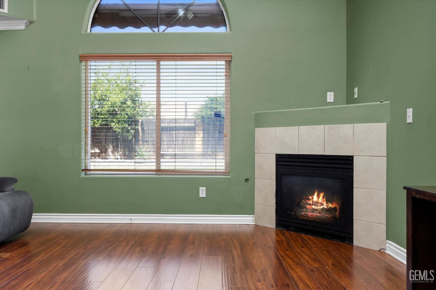Undisclosed Address Bakersfield, CA 93313 - Photo 16 of 48 a living room with a fireplace and a wooden floor