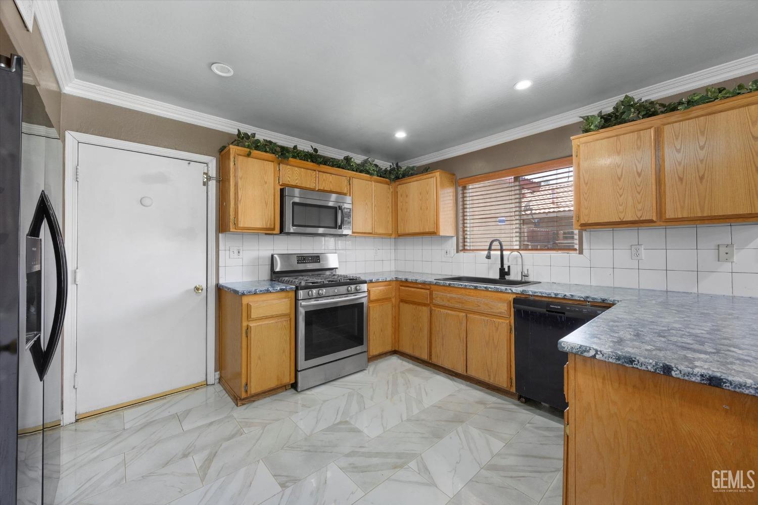 Undisclosed Address Bakersfield, CA 93313 - Photo 24 of 48 a large kitchen with stainless steel appliances granite countertop a stove a sink dishwasher a refrigerator and a microwave oven