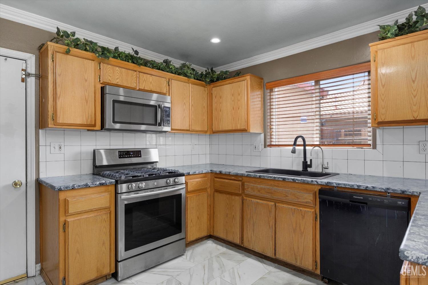Undisclosed Address Bakersfield, CA 93313 - Photo 25 of 48 a kitchen with stainless steel appliances granite countertop wooden cabinets stove top oven and sink