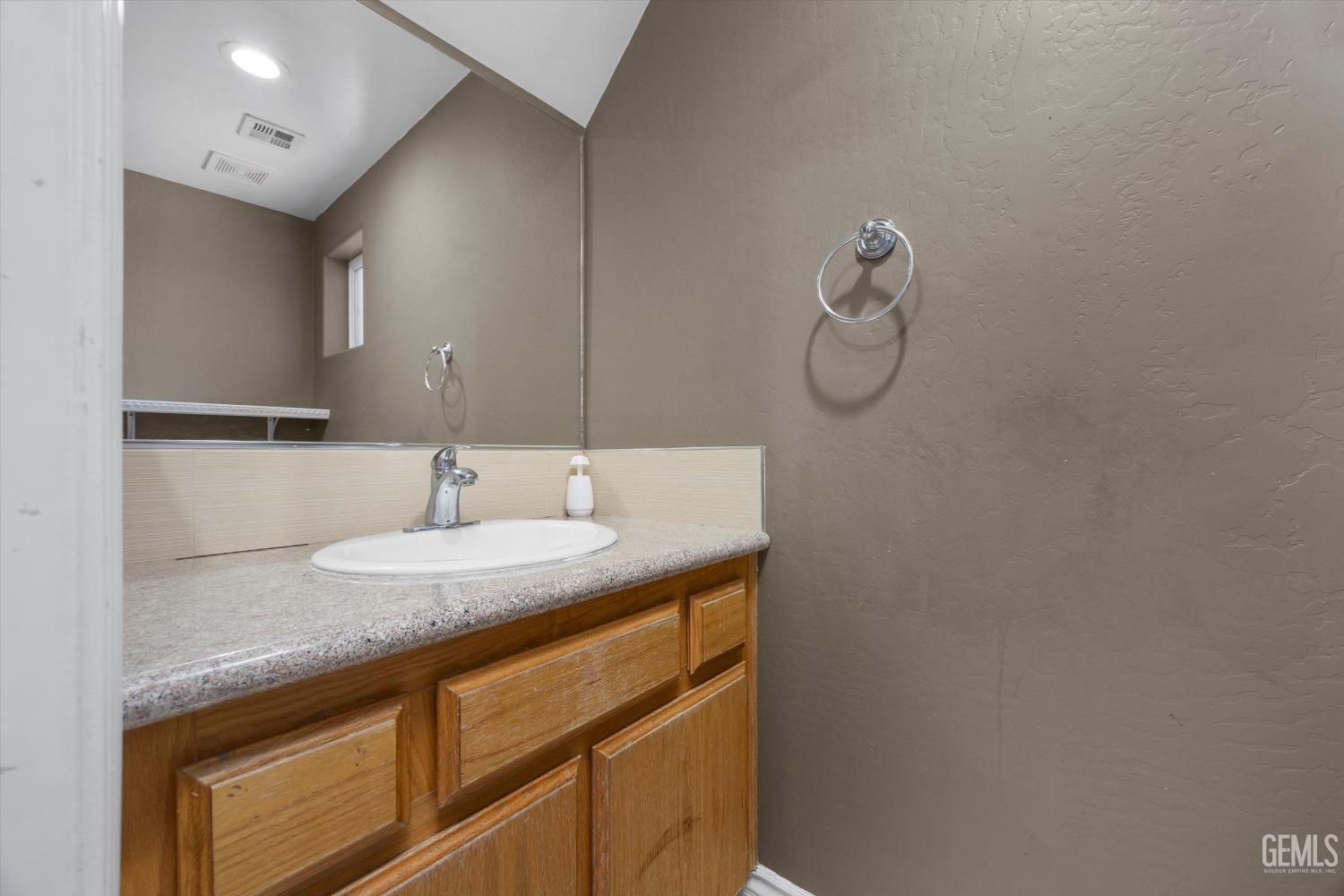Undisclosed Address Bakersfield, CA 93313 - Photo 28 of 48 a bathroom with a granite countertop sink and a mirror