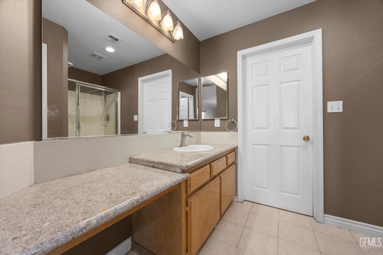 Undisclosed Address Bakersfield, CA 93313 - Photo 33 of 48 a bathroom with a granite countertop sink and a mirror