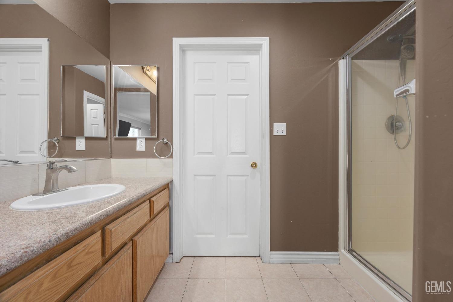Undisclosed Address Bakersfield, CA 93313 - Photo 34 of 48 a bathroom with a granite countertop sink two mirror and shower
