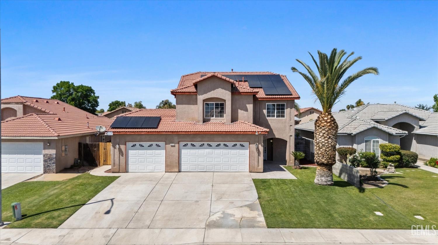 Undisclosed Address Bakersfield, CA 93313 - Photo 9 of 48 a front view of a house with a yard and garage