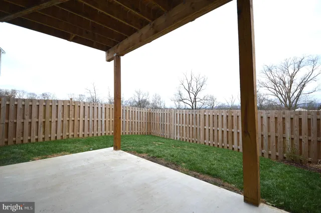 a view of a backyard with wooden fence
