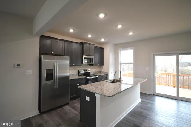 a kitchen with kitchen island a sink stainless steel appliances and window