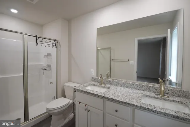 a bathroom with a granite countertop sink toilet and shower