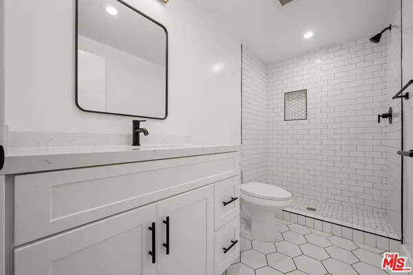 a kitchen with stainless steel appliances granite countertop white cabinets a sink a stove a microwave and cabinetry