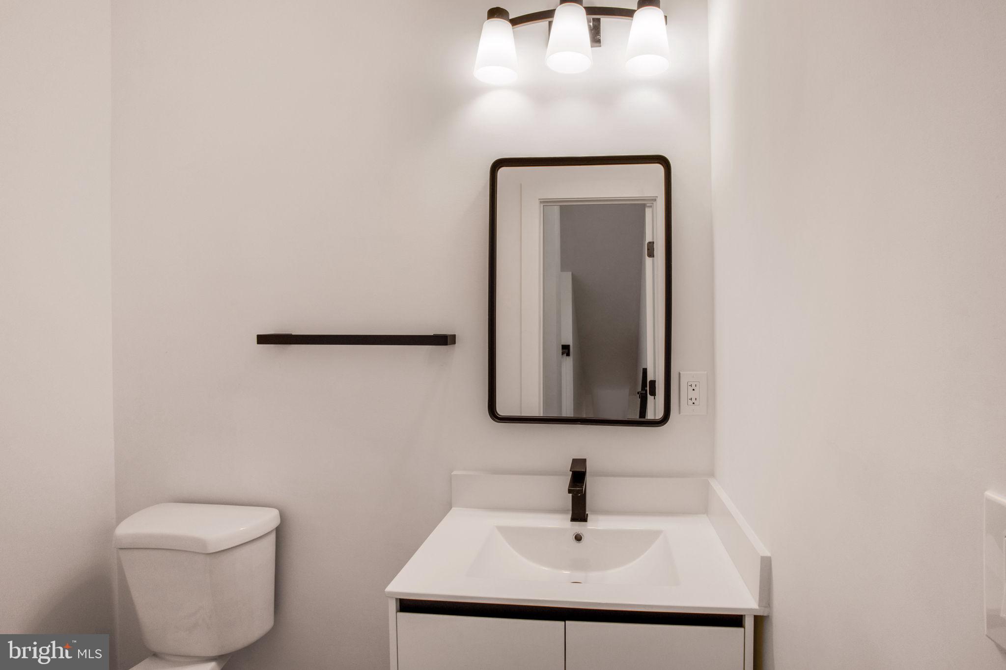 1211 Rhode Island Avenue Northwest, Unit 1 Washington, DC 20005 - Photo 11 of 24 a bathroom with a toilet a sink and mirror