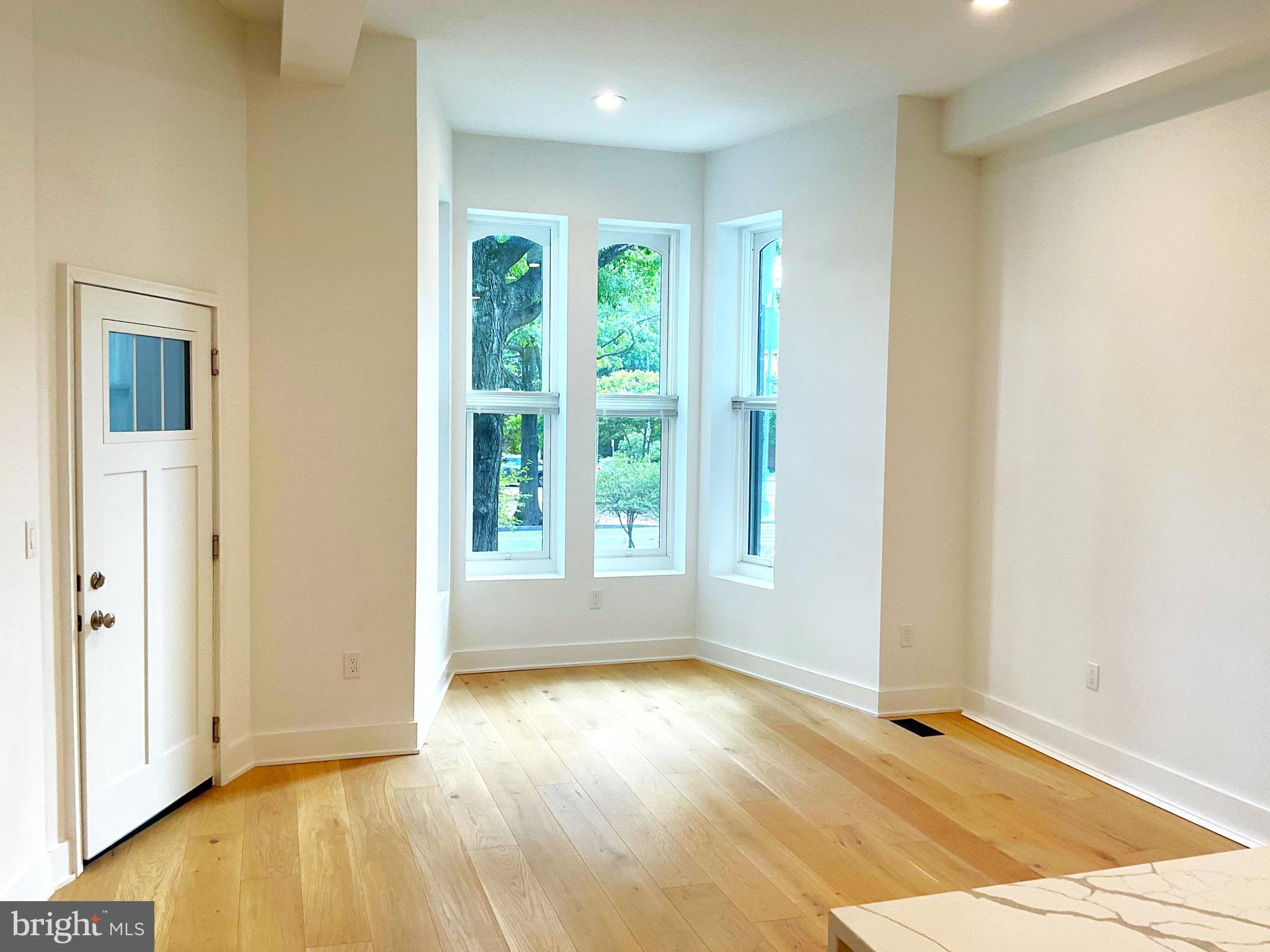 1211 Rhode Island Avenue Northwest, Unit 1 Washington, DC 20005 - Photo 4 of 24 a view of an empty room with wooden floor and a window