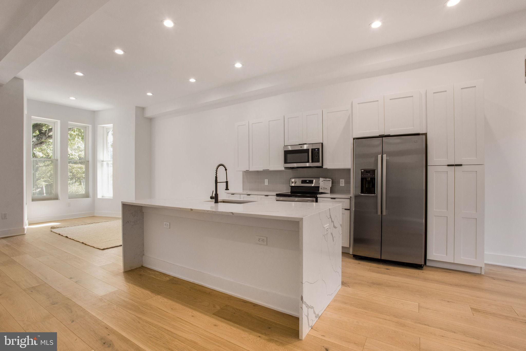 1211 Rhode Island Avenue Northwest, Unit 1 Washington, DC 20005 - Photo 6 of 24 a kitchen with stainless steel appliances a refrigerator sink and microwave