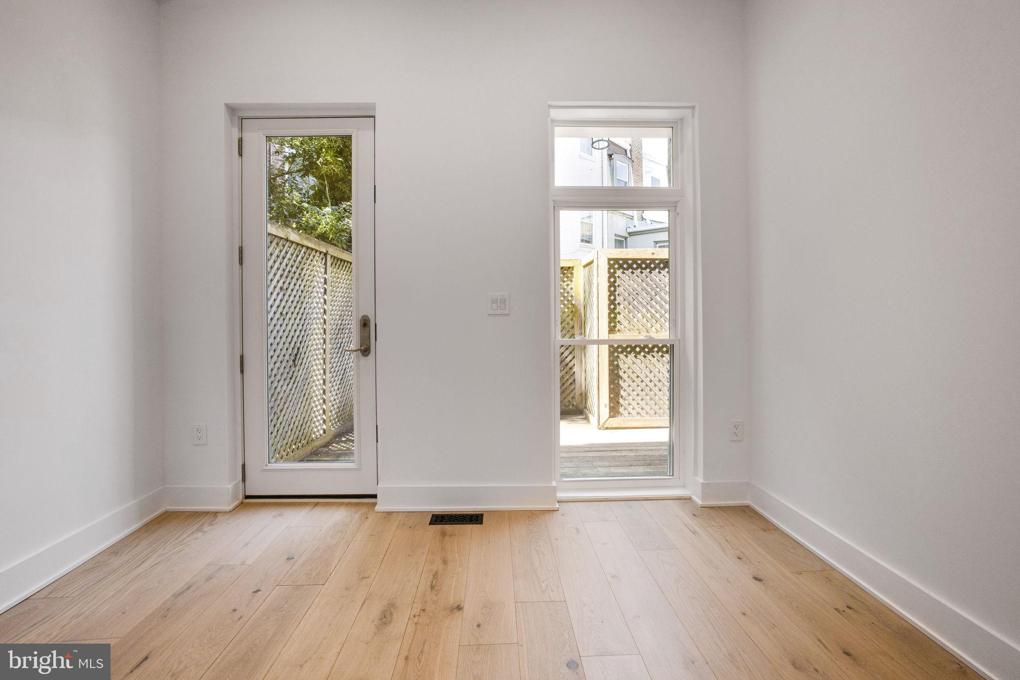 1211 Rhode Island Avenue Northwest, Unit 1 Washington, DC 20005 - Photo 10 of 24 an empty room with wooden floor and windows
