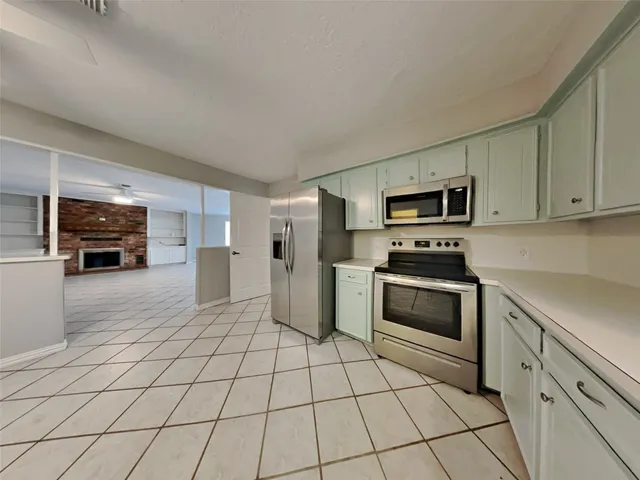 a kitchen with stainless steel appliances granite countertop a refrigerator and a stove top oven