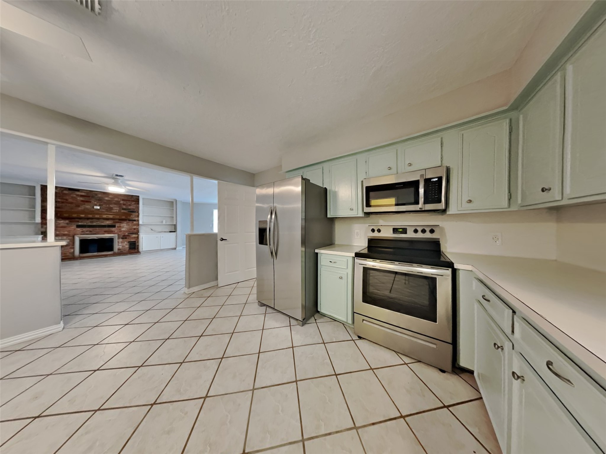 a kitchen with stainless steel appliances granite countertop a refrigerator and a stove top oven