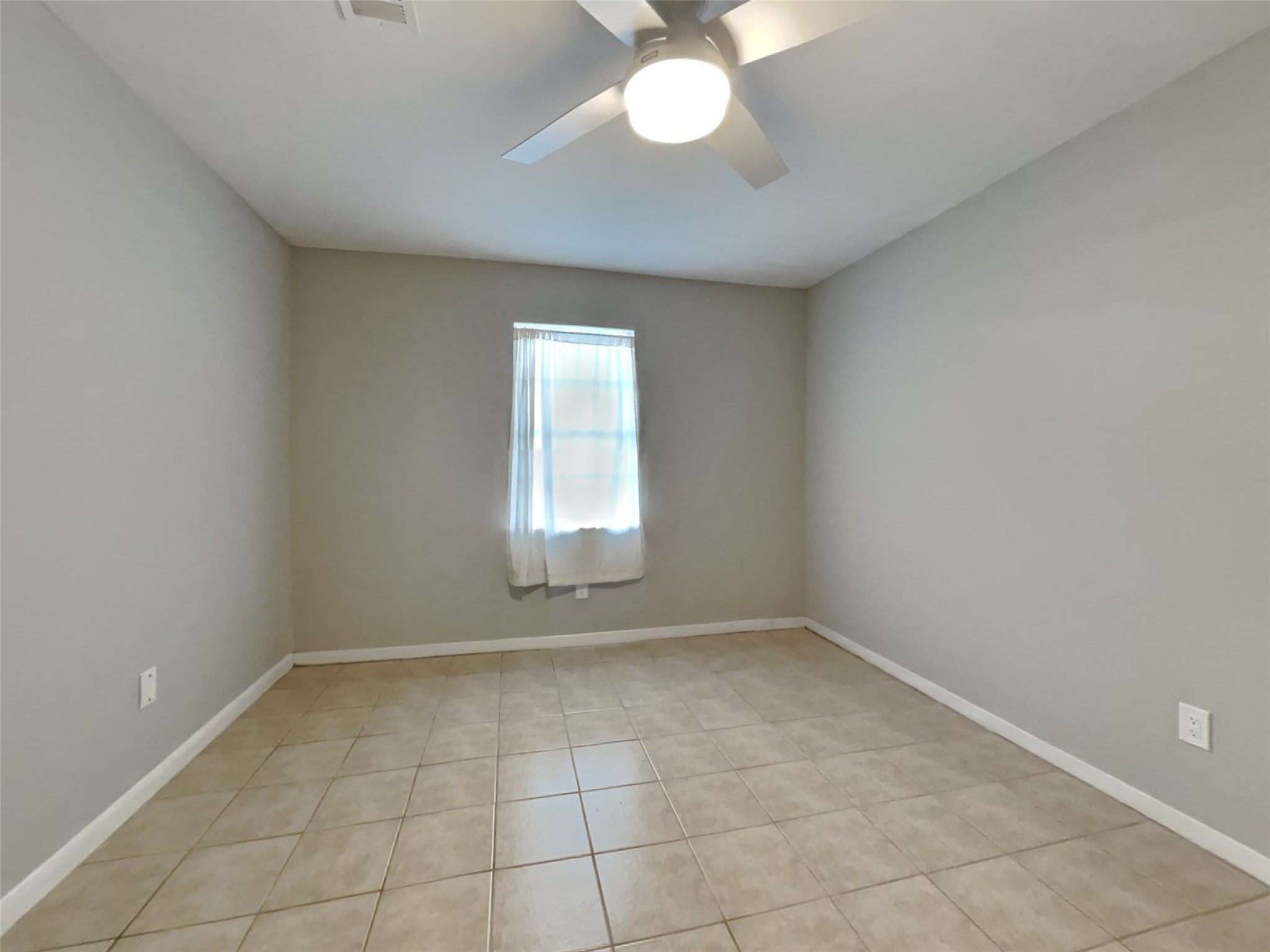 10648 Fussel Road, Unit A Conroe, TX 77385 - Photo 11 of 18 an empty room with a chandelier fan and windows