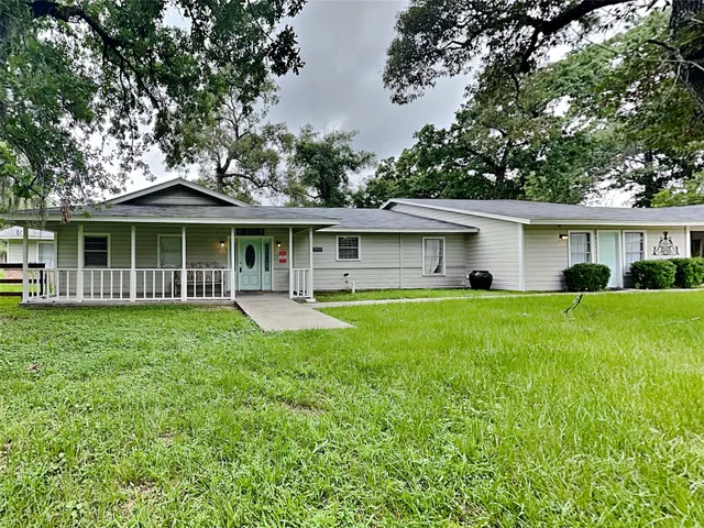 a front view of a house with a yard and trees