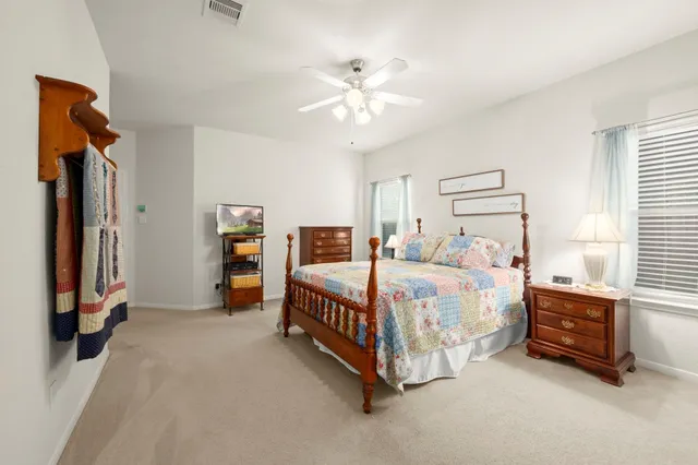 a spacious bedroom with a bed and a chandelier